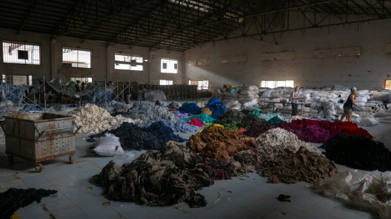 Francois le Nguyen clothing factory with fabrics on the floor