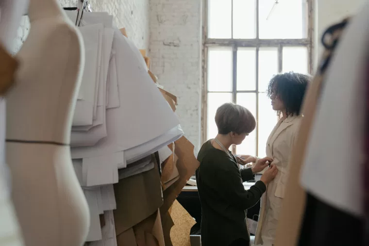 Woman adjusting clothes on a model.