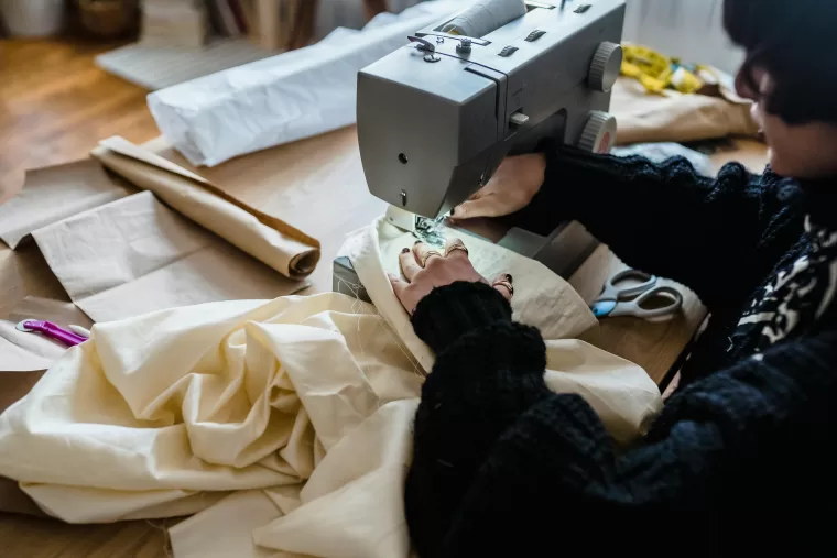 Woman sewing fabric on a sewing machine.