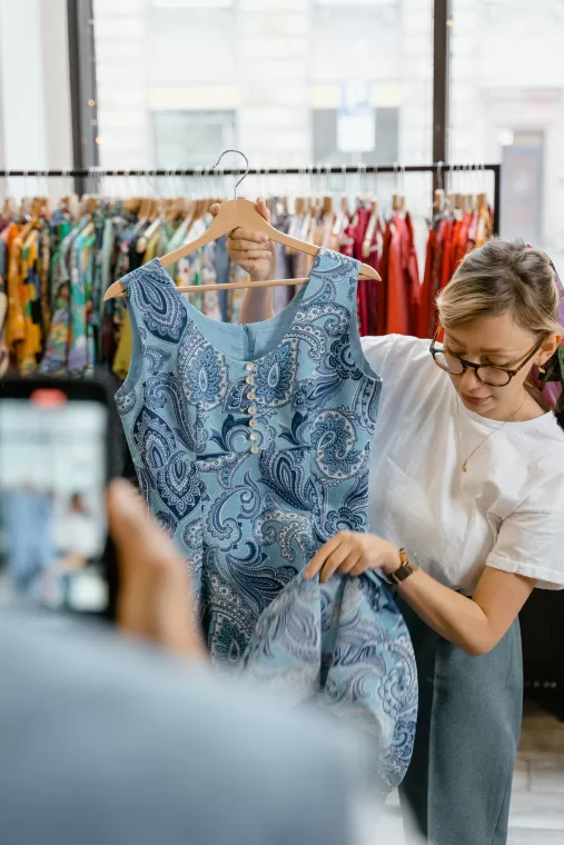 Shop attendant showing garment to customer