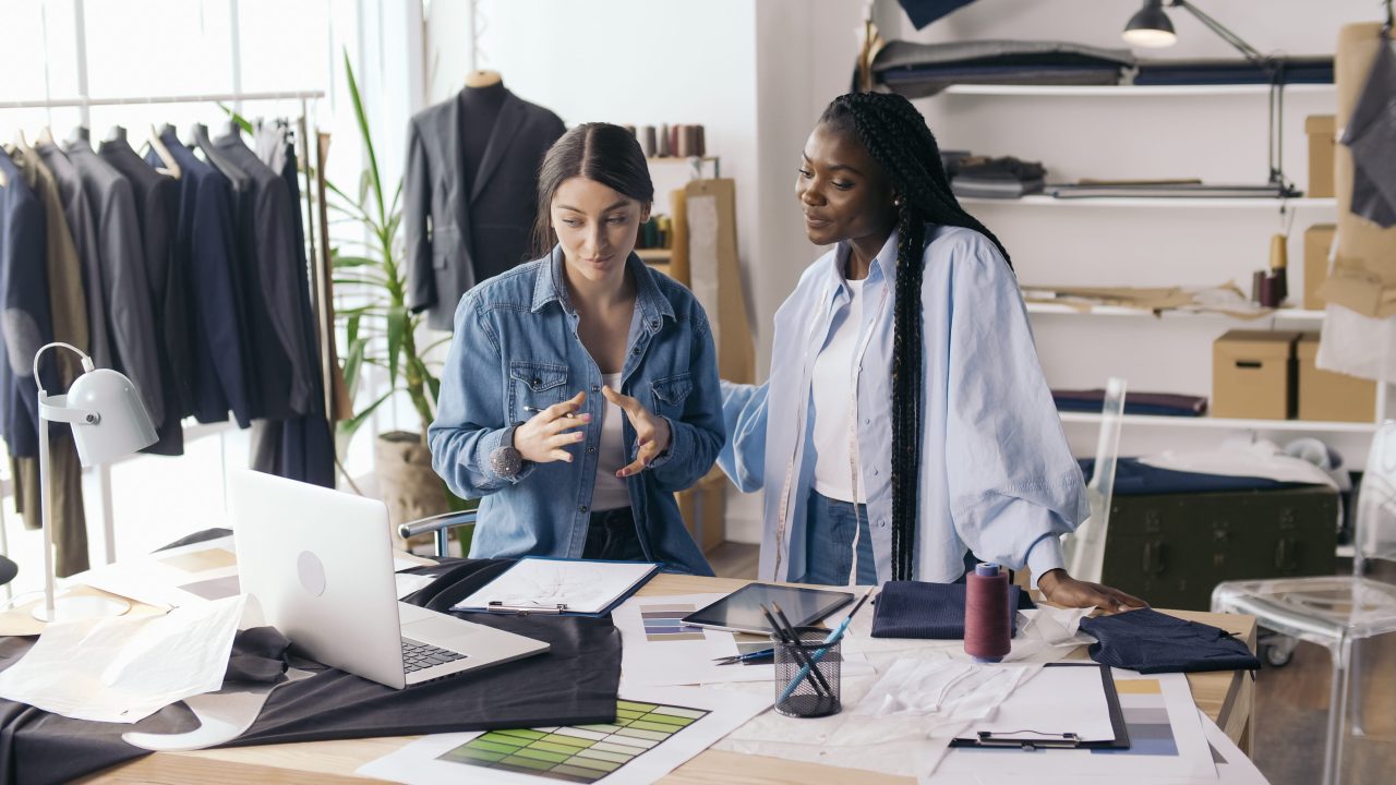Two fashion designers discussing plans in a studio